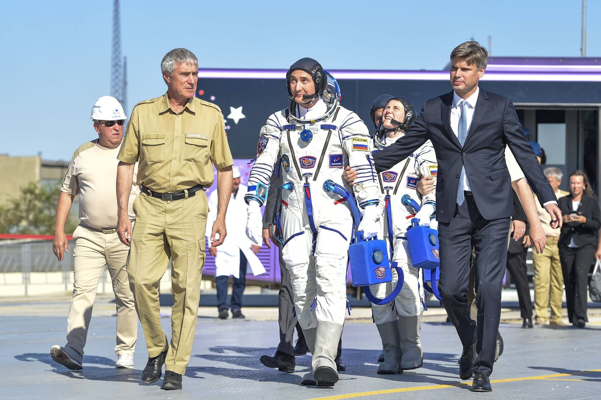 Sergueï Krikalyov et Dmitry Bakanov accompagnent Pyotr Doubrov au pied de la fusée.