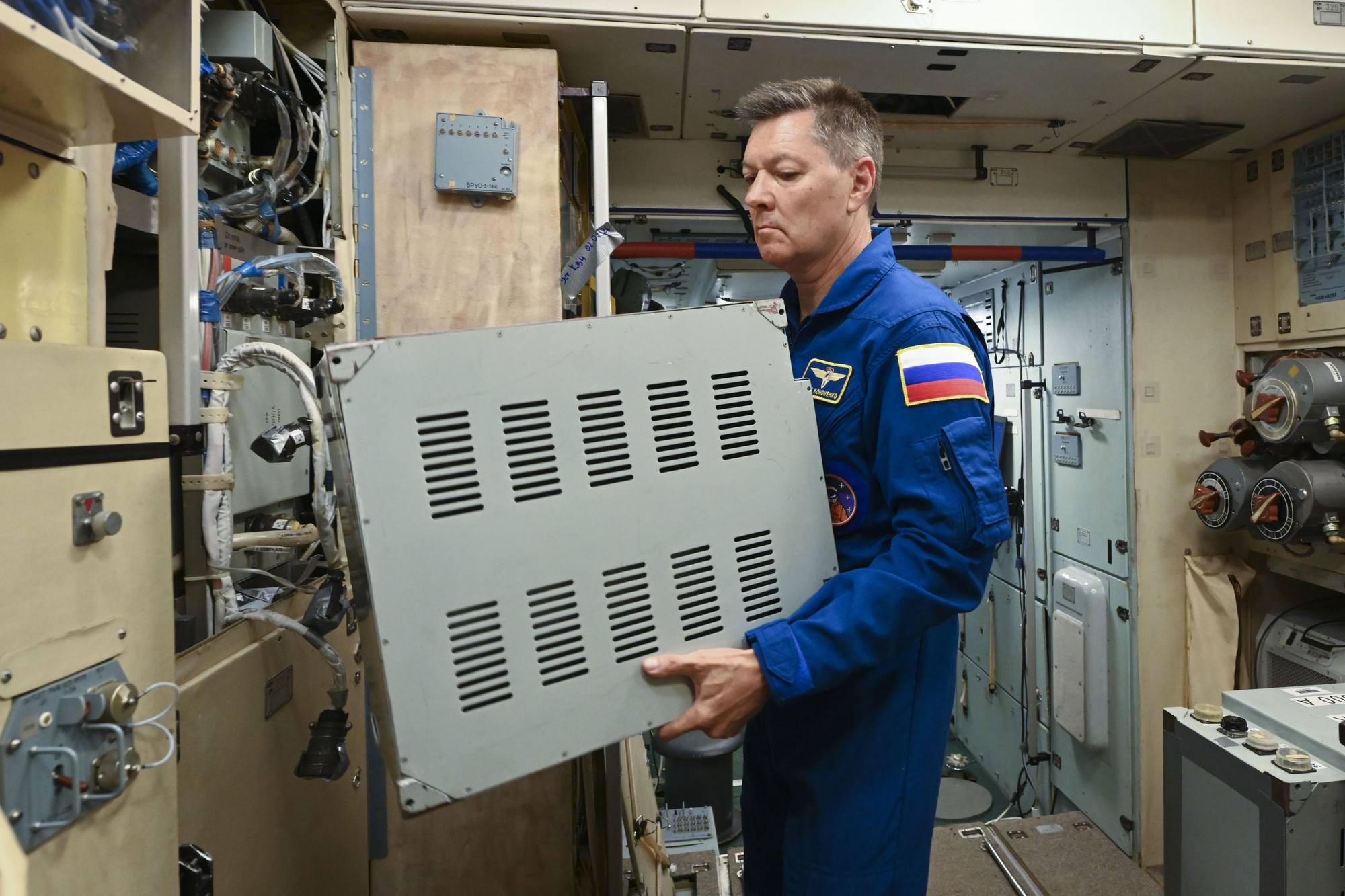 Oleg Kononenko ouvrant un des panneaux d'instruments.